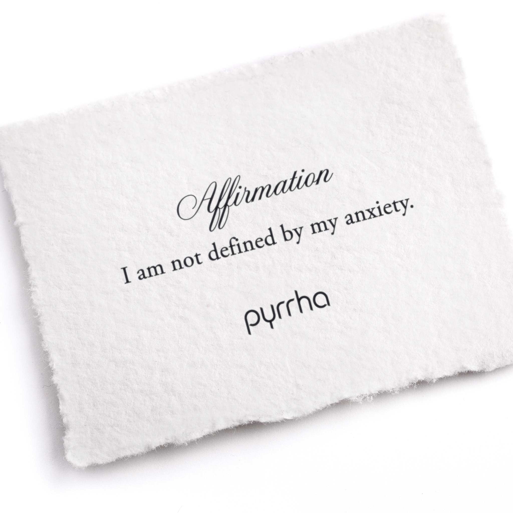 A hand-torn, letterpress printed card describing the meaning for Pyrrha's i am not defined by my anxiety Affirmation Talisman