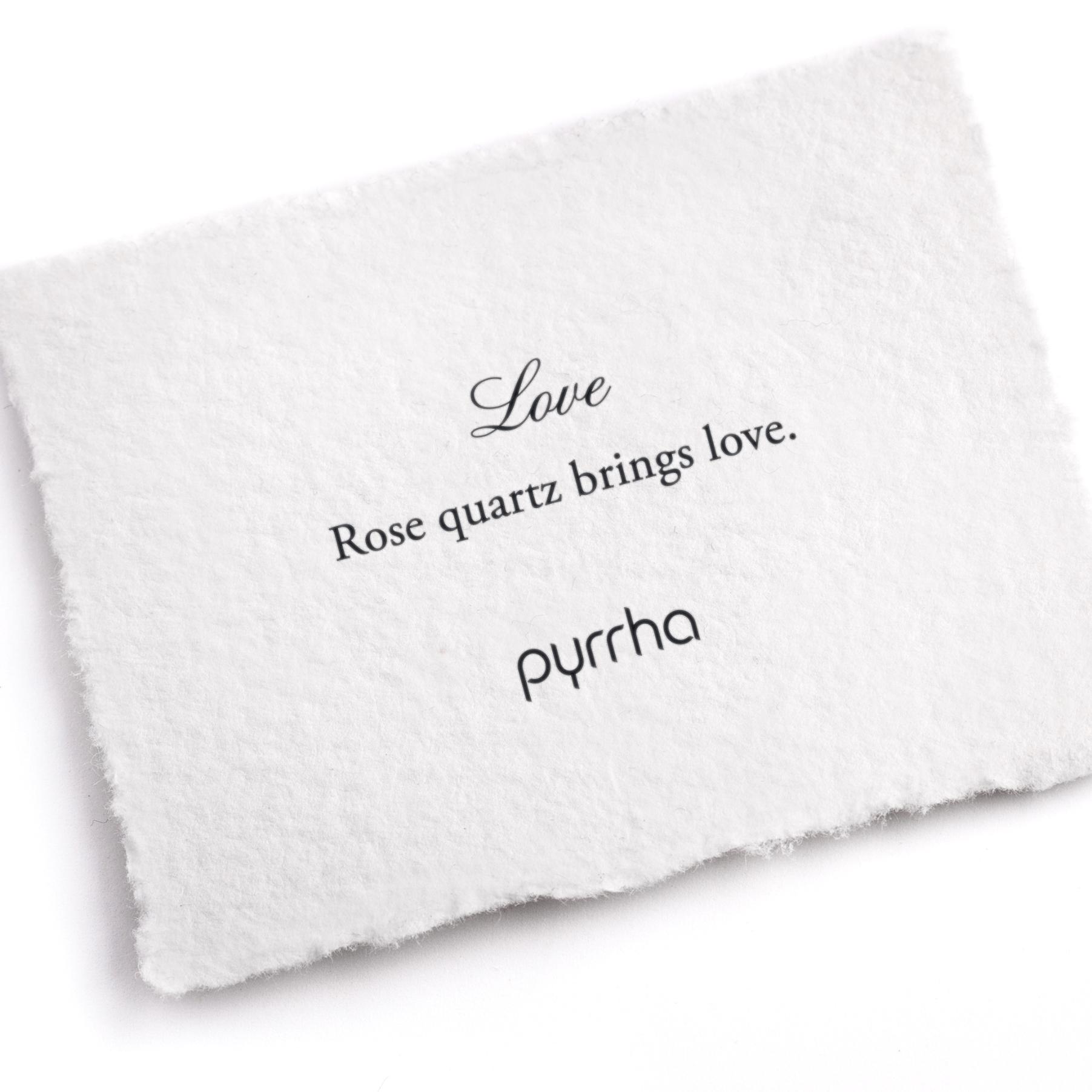 A hand-torn, letterpress printed card describing the meaning for Pyrrha's Love Attraction Charm
