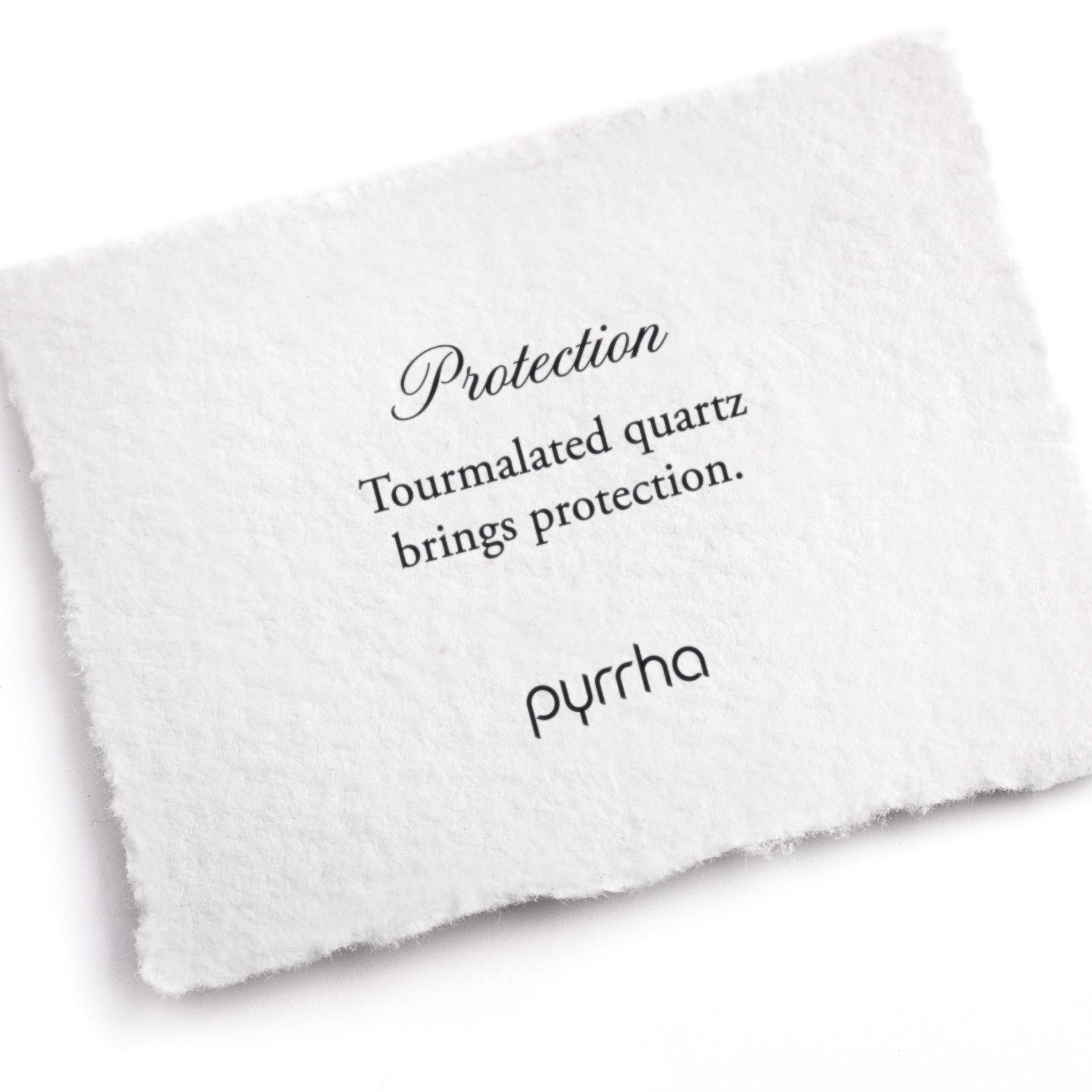 A hand-torn, letterpress printed card describing the meaning for Pyrrha's Protection Attraction Charm
