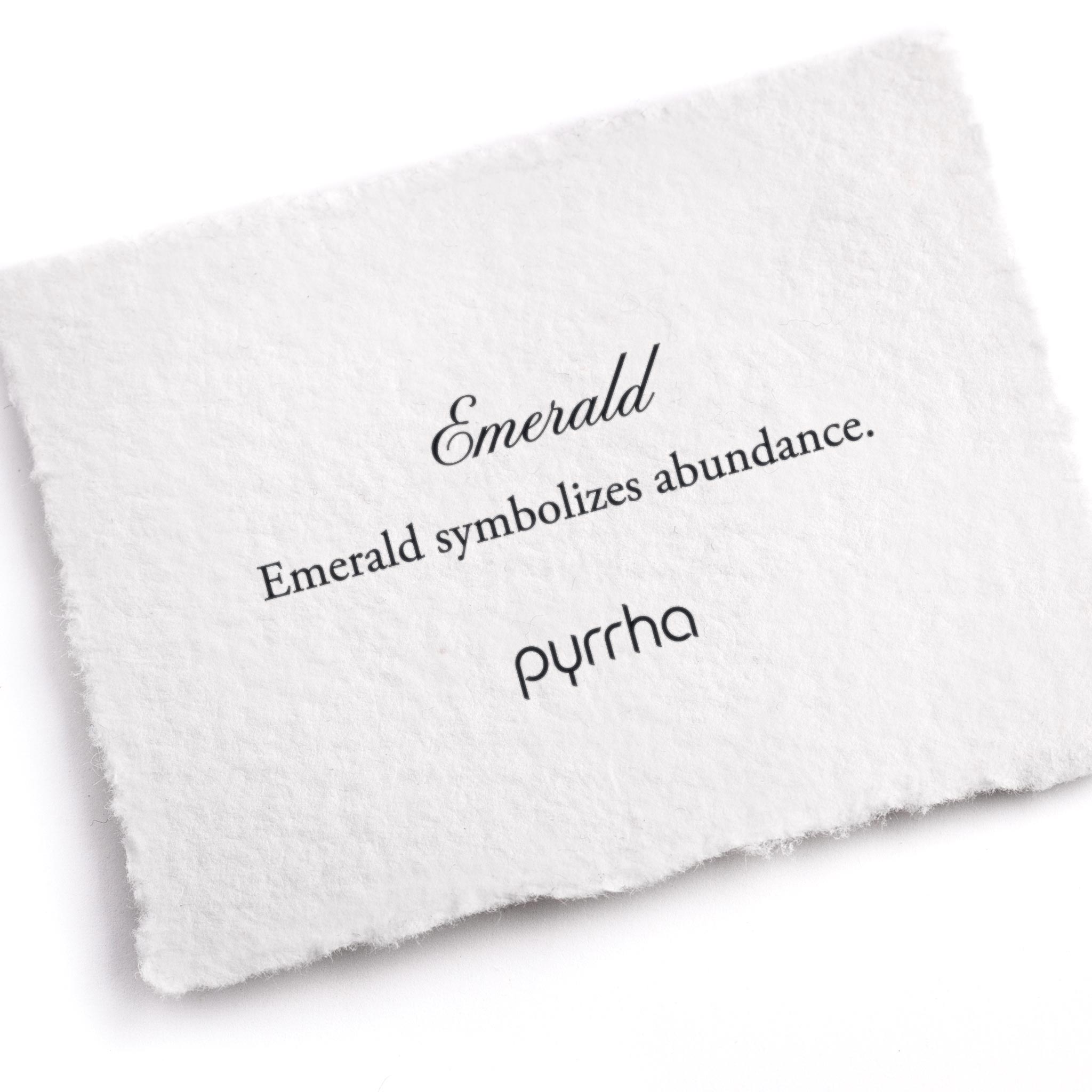 A hand-torn, letterpress printed card describing the meaning for Pyrrha's Emerald stone