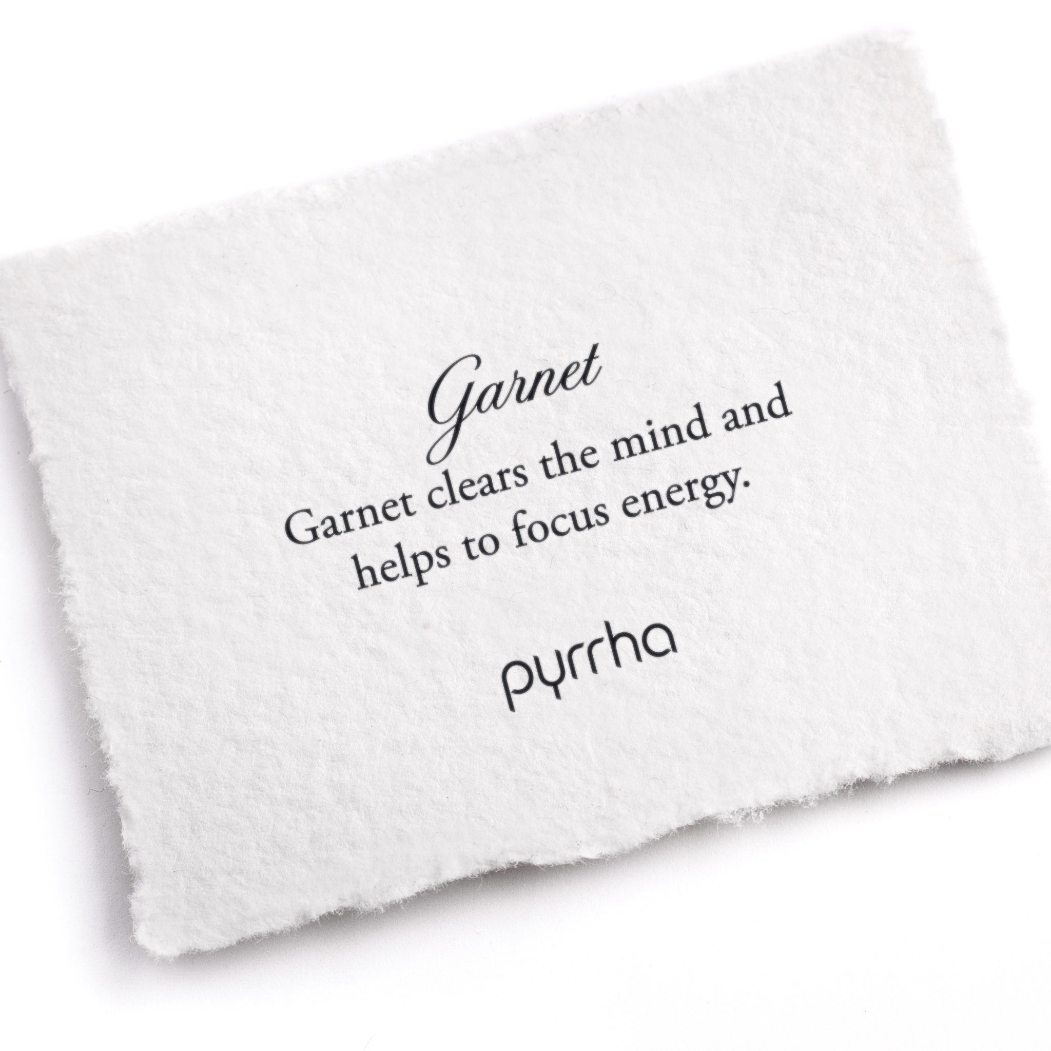 A hand-torn, letterpress printed card describing the meaning for Pyrrha's Garnet stone