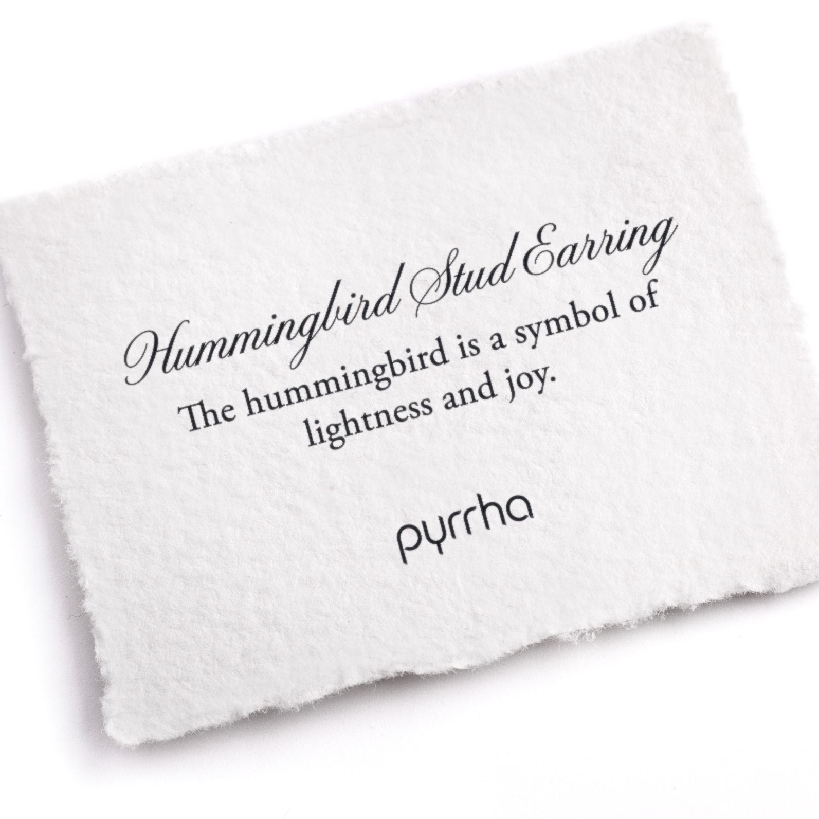 A hand-torn, letterpress printed card describing the meaning for Pyrrha's Hummingbird Charm