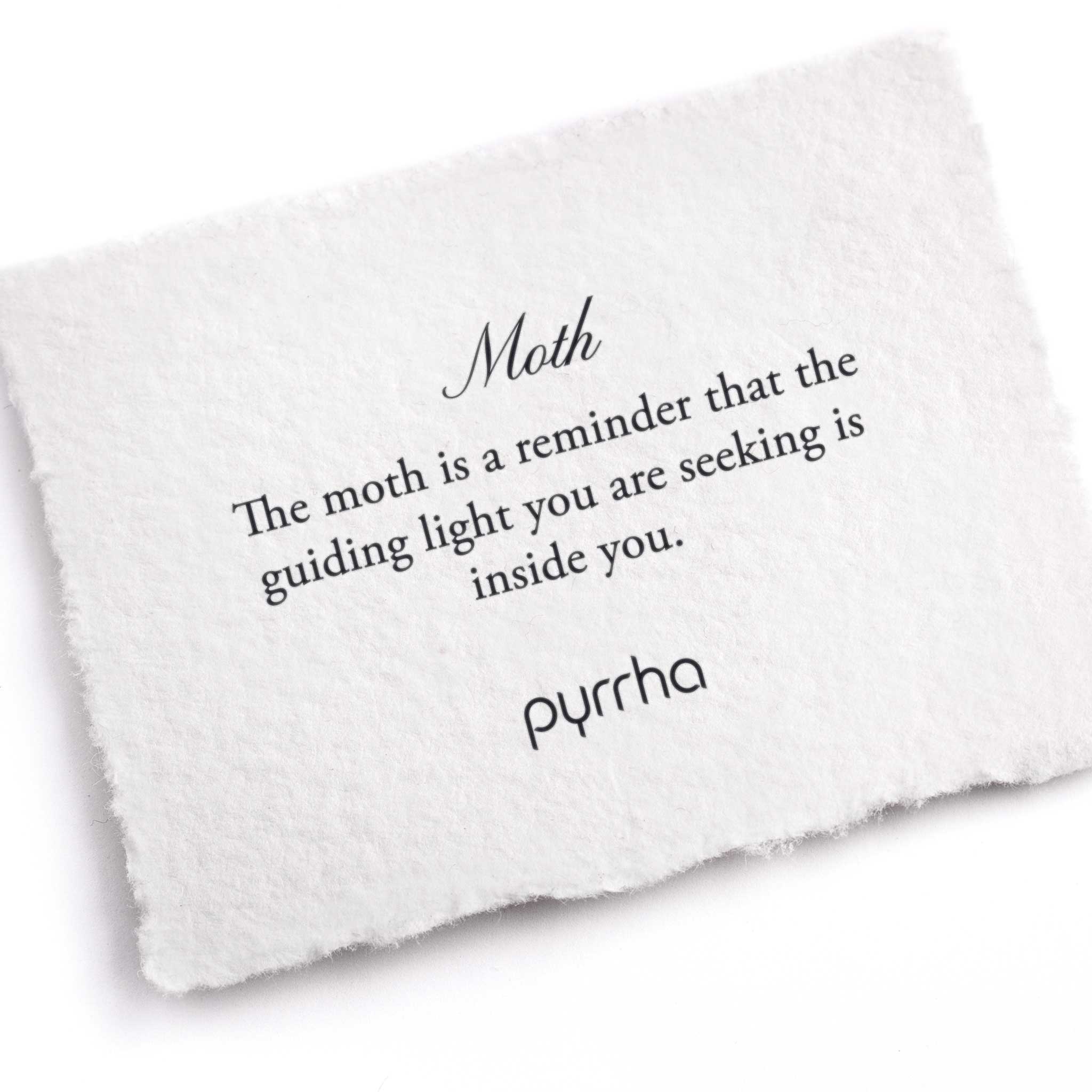 A hand-torn, letterpress printed card describing the meaning for Pyrrha's Moth Charm