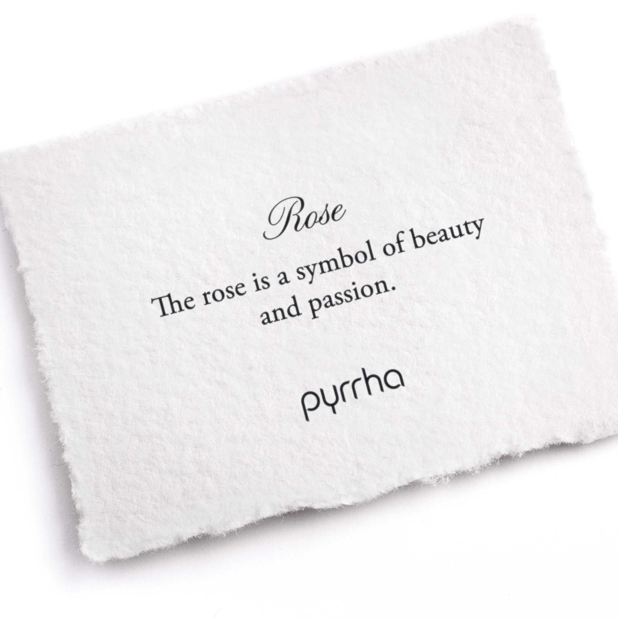 A hand-torn, letterpress printed card describing the meaning for Pyrrha's Rose Charm