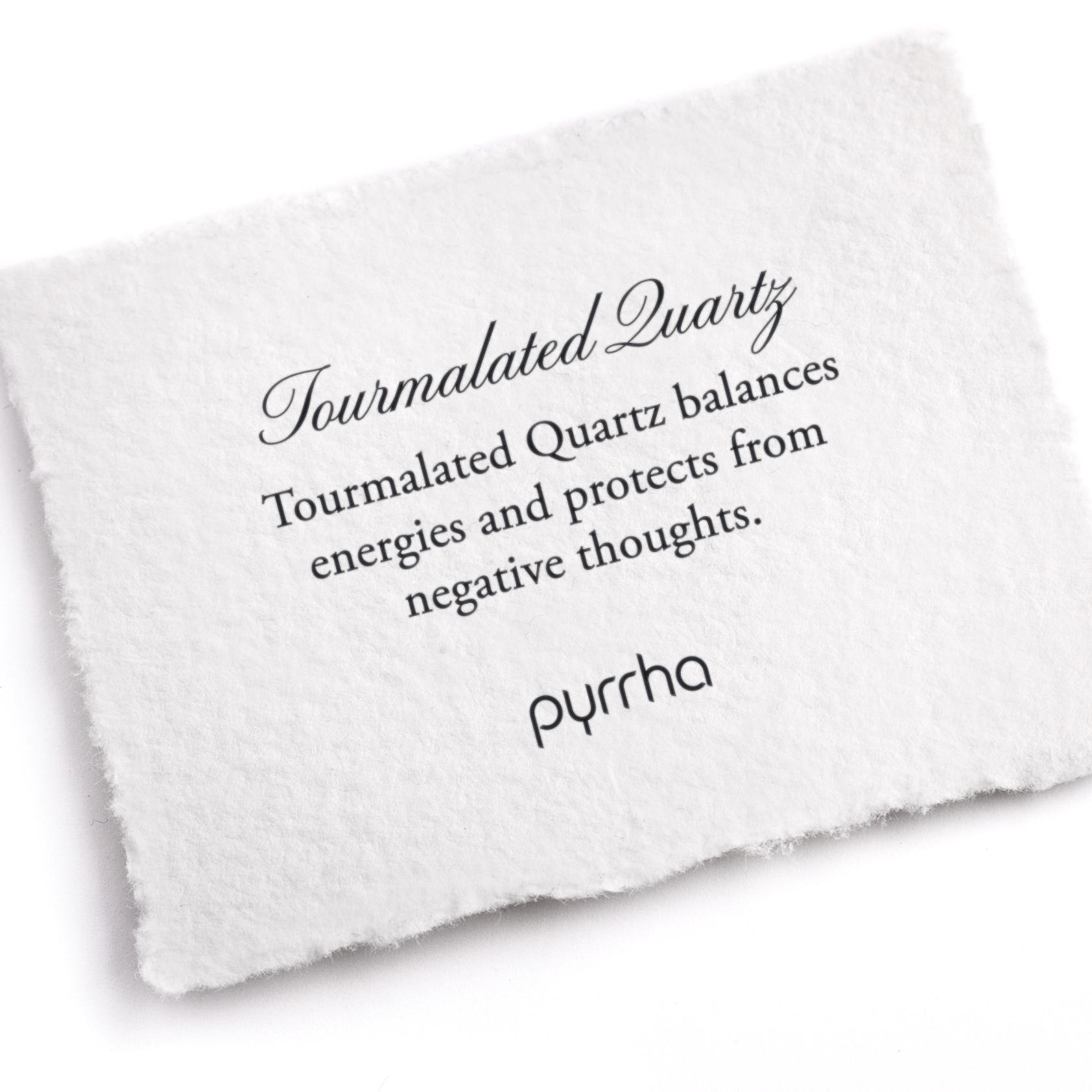A hand-torn, letterpress printed card describing the meaning for Pyrrha's Tourmalated Quartz stone