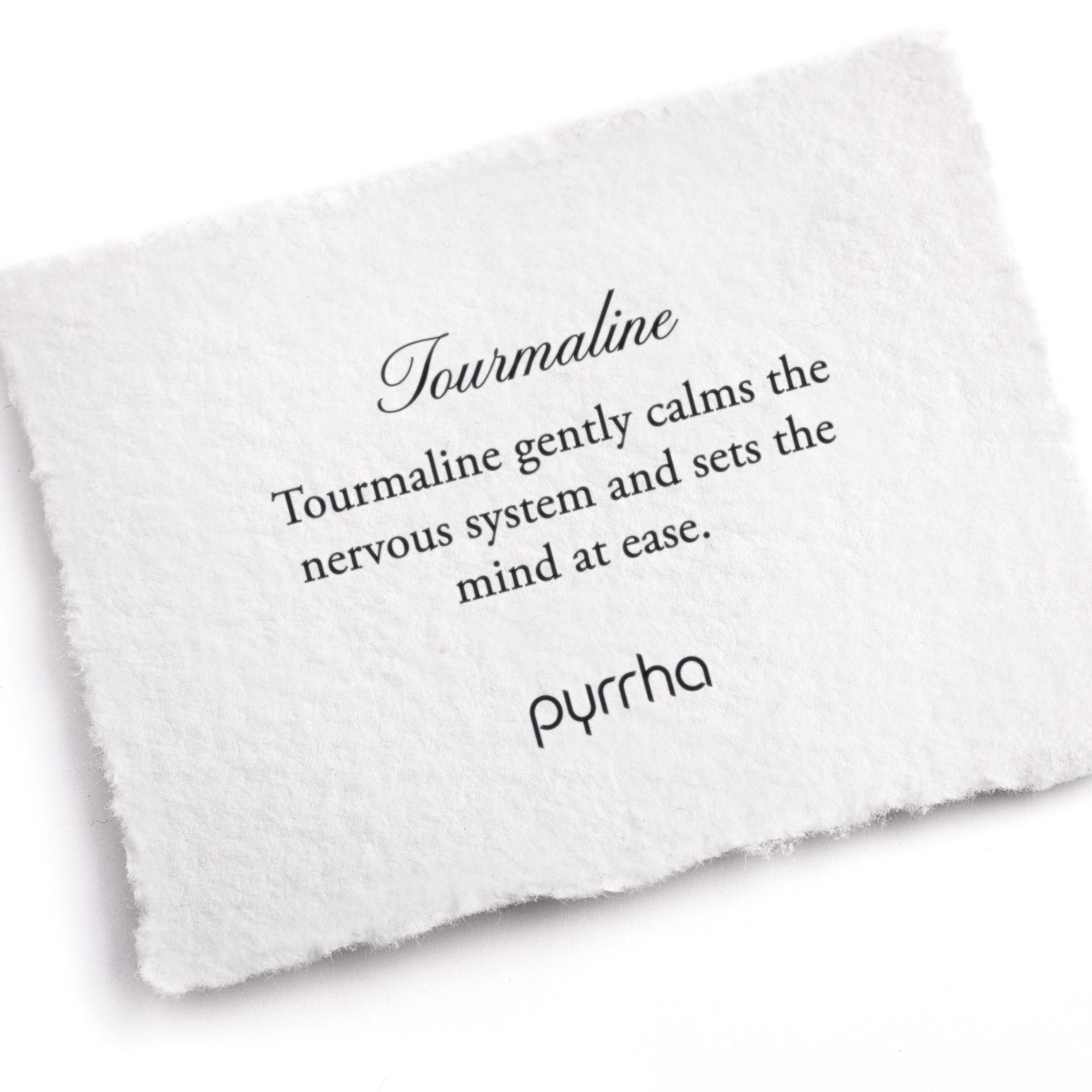 A hand-torn, letterpress printed card describing the meaning for Pyrrha's Tourmaline stone